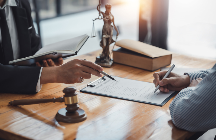 client signing a legal agreement with lawyer assistance - business lawyer keene nh