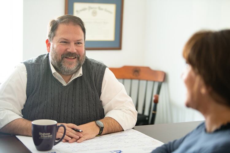 Chris from Shaheen & Gordon sitting at a table in a meeting - What Is Mediation in a Maine Personal Injury Case?