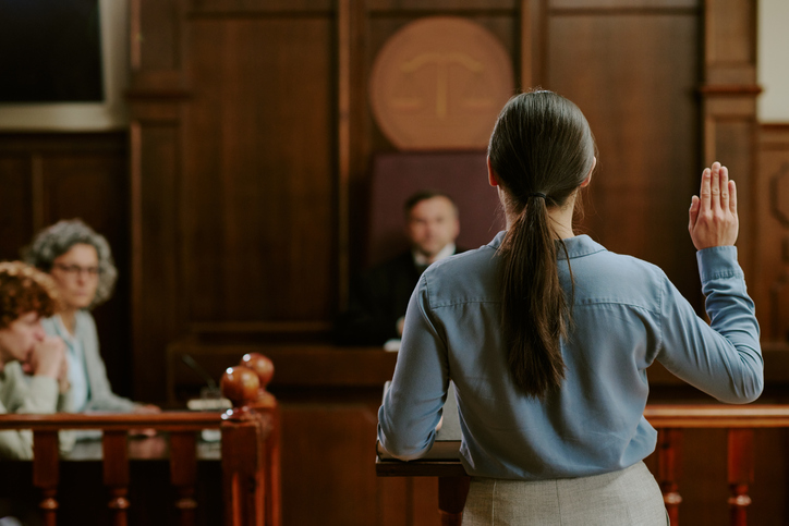 woman testifying in a courtroom in front of a judge - what are federal charges?