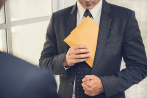 businessman putting Businessman putting an envelope into his suit pocket - How long after theft can you be charged in New Hampshire?